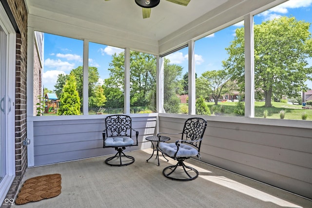 unfurnished sunroom featuring a ceiling fan and a healthy amount of sunlight