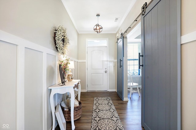 foyer with crown molding, visible vents, a barn door, and dark wood-style flooring