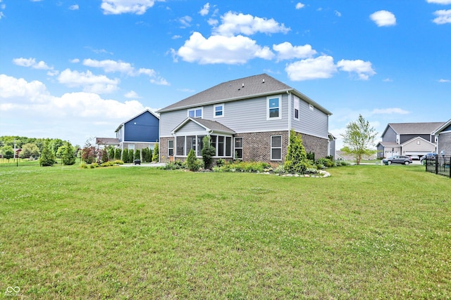 back of house featuring a lawn and brick siding