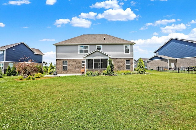 back of house featuring brick siding, fence, and a yard