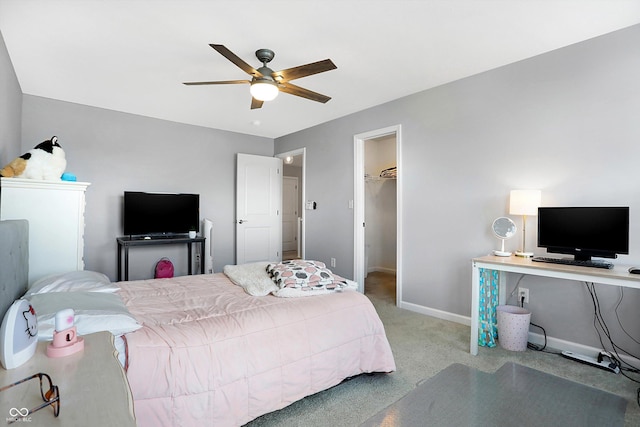 bedroom featuring a spacious closet, baseboards, carpet floors, ceiling fan, and a closet