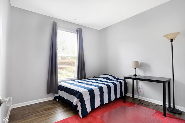 bedroom with baseboards and wood finished floors