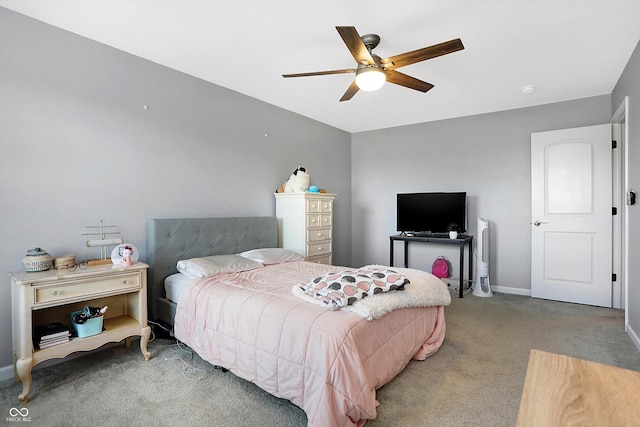 carpeted bedroom featuring baseboards and a ceiling fan