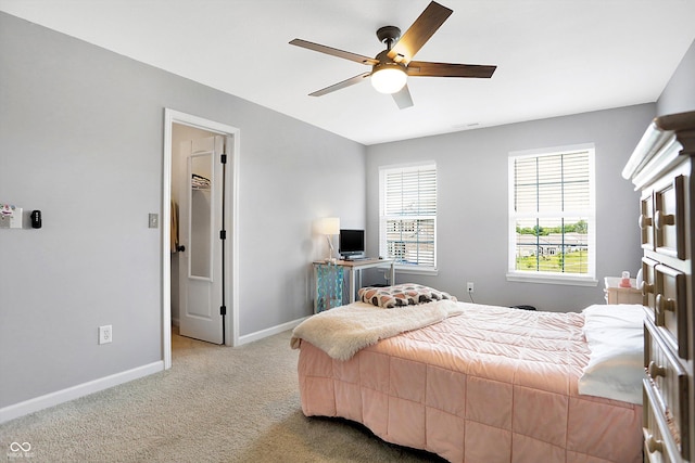 carpeted bedroom featuring a spacious closet, a ceiling fan, and baseboards