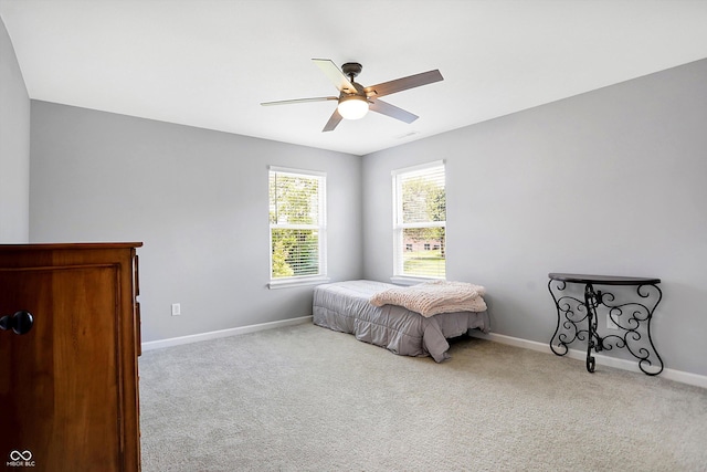 carpeted bedroom featuring baseboards and a ceiling fan