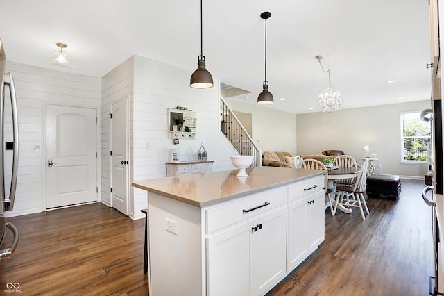 kitchen featuring dark wood-type flooring, white cabinetry, decorative light fixtures, and light countertops