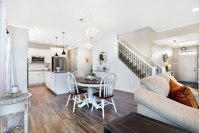dining room featuring an inviting chandelier, recessed lighting, stairs, and wood finished floors