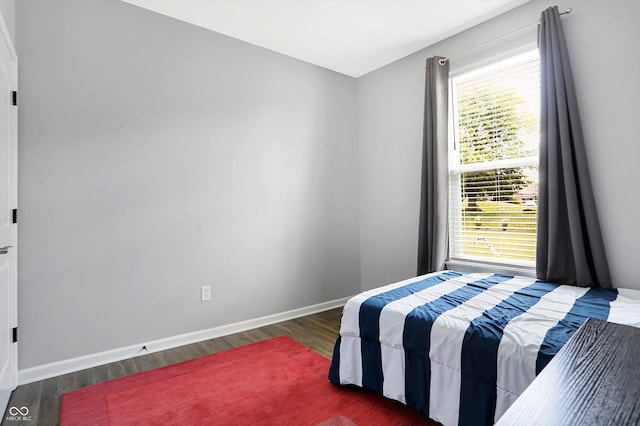 bedroom featuring baseboards and wood finished floors