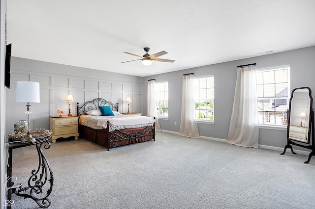 carpeted bedroom featuring baseboards, visible vents, and ceiling fan