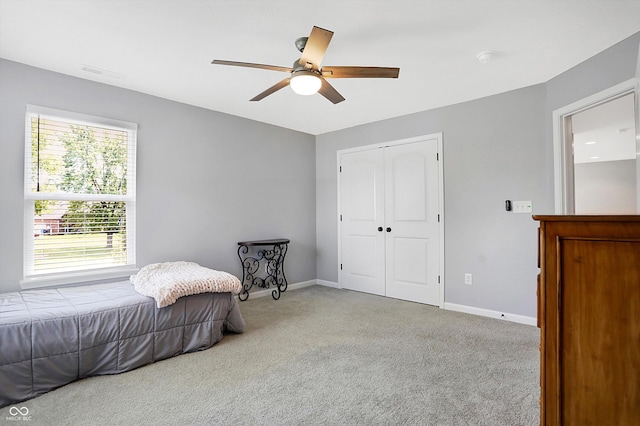 carpeted bedroom with baseboards, visible vents, a closet, and a ceiling fan