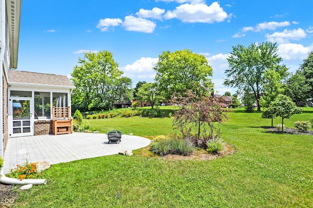view of yard featuring a sunroom, a fire pit, and a patio area
