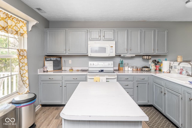 329 Dogwood Dr, Pendleton, IN 46064 - kitchen with white appliances, a sink, gray cabinetry, light countertops, and a textured ceiling