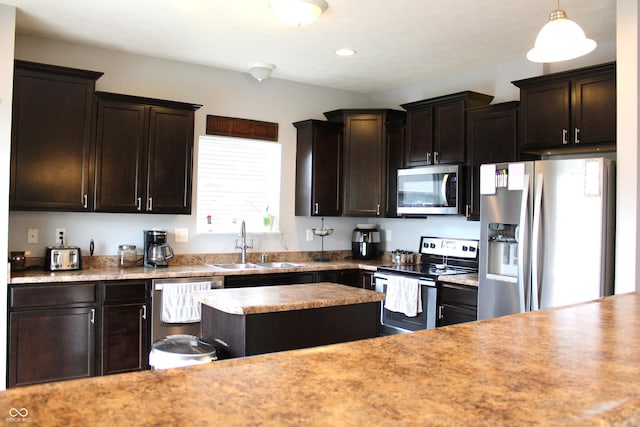 981 Redwood Dr, Franklin, IN 46131 - kitchen with stainless steel appliances, dark brown cabinets, light countertops, a kitchen island, and hanging light fixtures