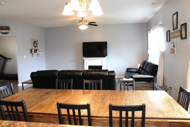 981 Redwood Dr, Franklin, IN 46131 - dining room featuring a ceiling fan, wood finished floors, a fireplace, and a chandelier