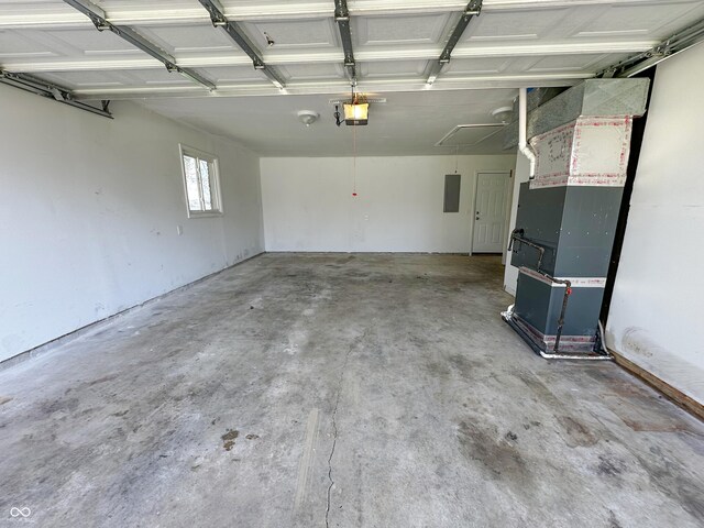 garage featuring heating unit, a garage door opener, and electric panel