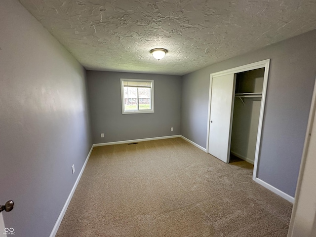 unfurnished bedroom with baseboards, a closet, and carpet