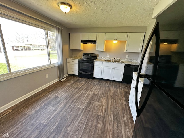 kitchen featuring visible vents, range hood, dark wood finished floors, a sink, and black appliances