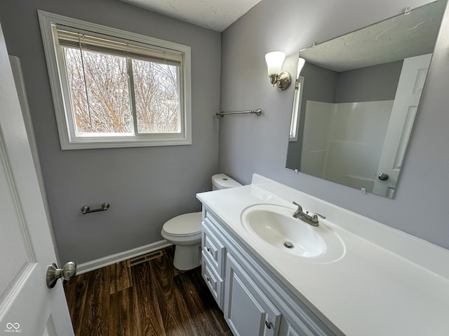 full bathroom featuring toilet, a shower, vanity, wood finished floors, and baseboards