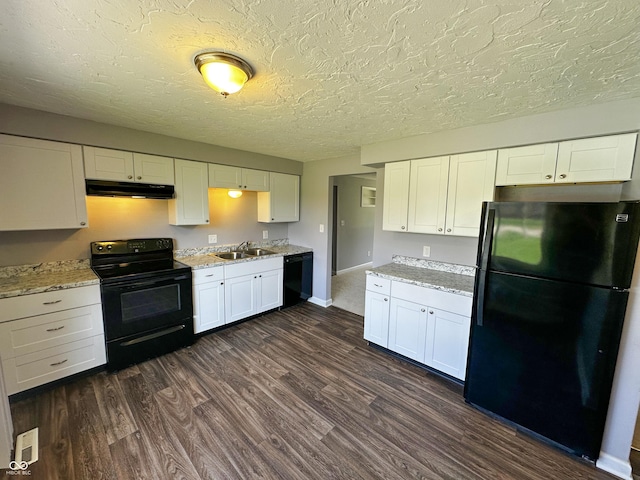 kitchen with under cabinet range hood, a sink, dark wood-style floors, white cabinets, and black appliances