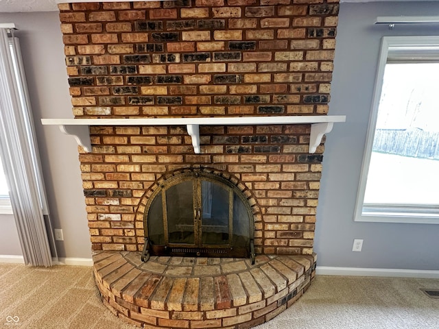 interior details featuring baseboards, visible vents, carpet flooring, and a fireplace