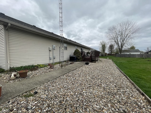 1310 Pin Oak Dr, Seymour, IN 47274 - view of home's exterior with a lawn, fence, a wooden deck, and central AC unit