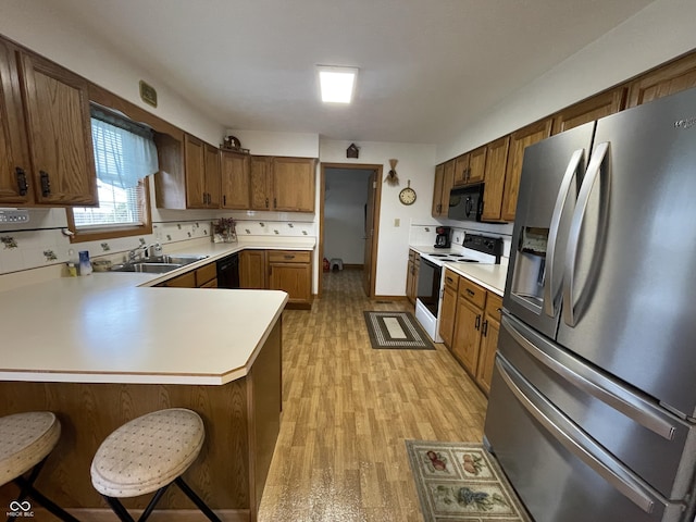 1310 Pin Oak Dr, Seymour, IN 47274 - kitchen featuring light countertops, a sink, a peninsula, and black appliances