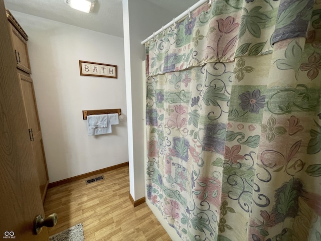 1310 Pin Oak Dr, Seymour, IN 47274 - full bath featuring baseboards, visible vents, a shower with shower curtain, and wood finished floors