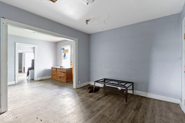 interior space featuring baseboards and wood finished floors