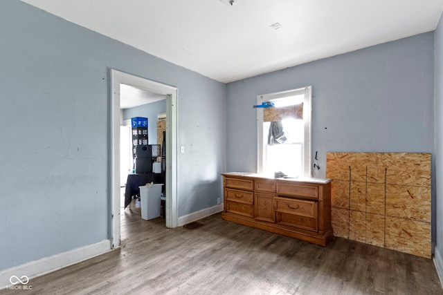 bedroom with baseboards and wood finished floors