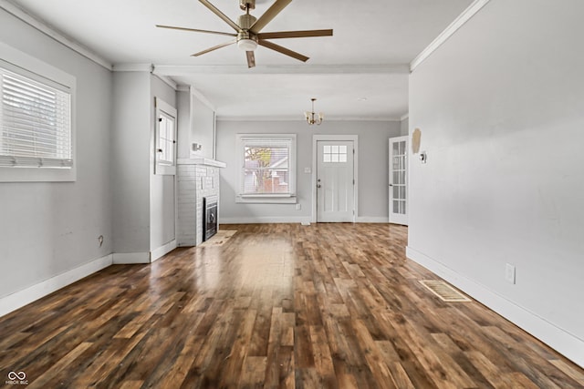 unfurnished living room featuring baseboards, dark wood-style flooring, ceiling fan with notable chandelier, and ornamental molding