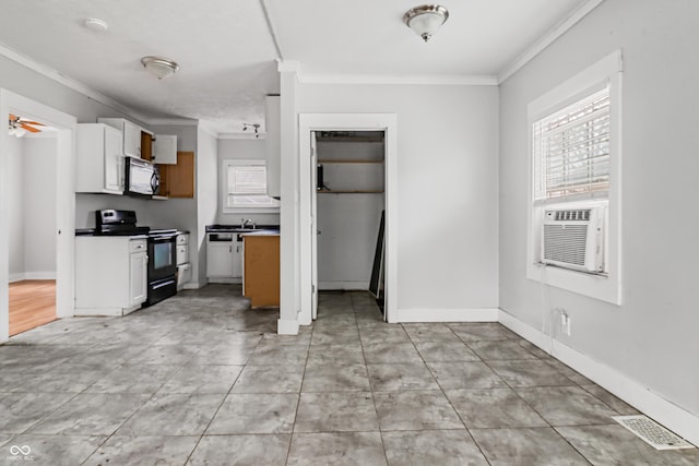 kitchen with crown molding, visible vents, baseboards, and black electric range oven