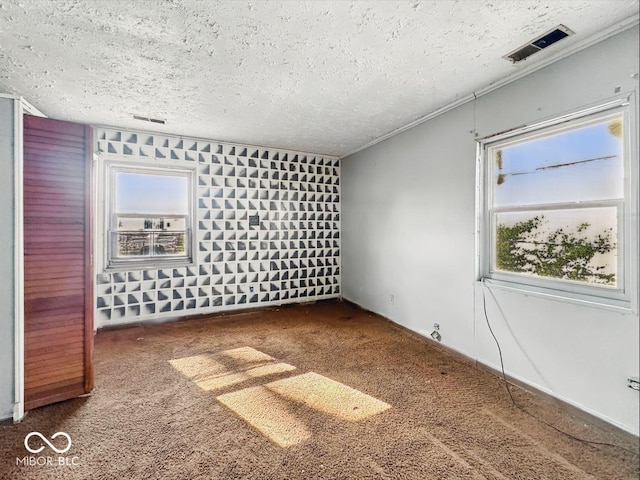 unfurnished bedroom with carpet, a textured ceiling, and visible vents