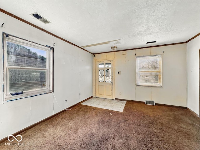 foyer with light colored carpet, visible vents, and ornamental molding