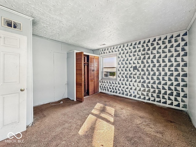 unfurnished bedroom with visible vents, carpet, a closet, and a textured ceiling