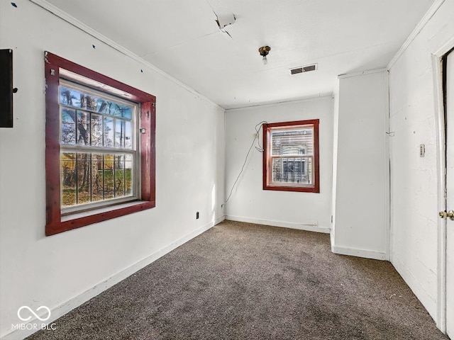 carpeted spare room featuring baseboards and visible vents