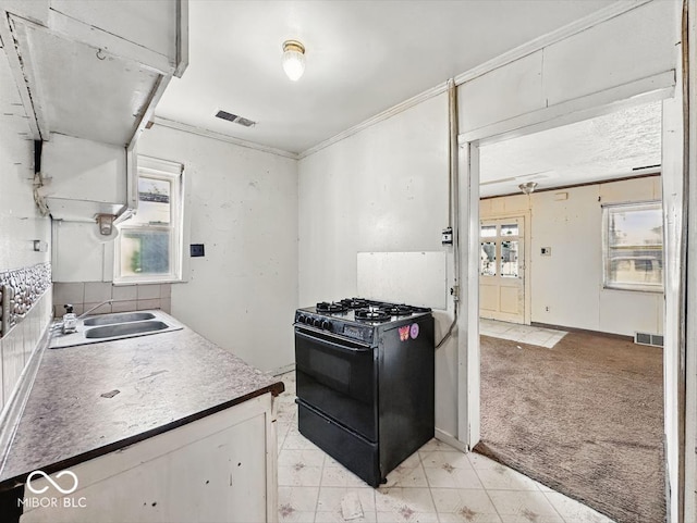 kitchen with a sink, black range with gas cooktop, a wealth of natural light, and visible vents