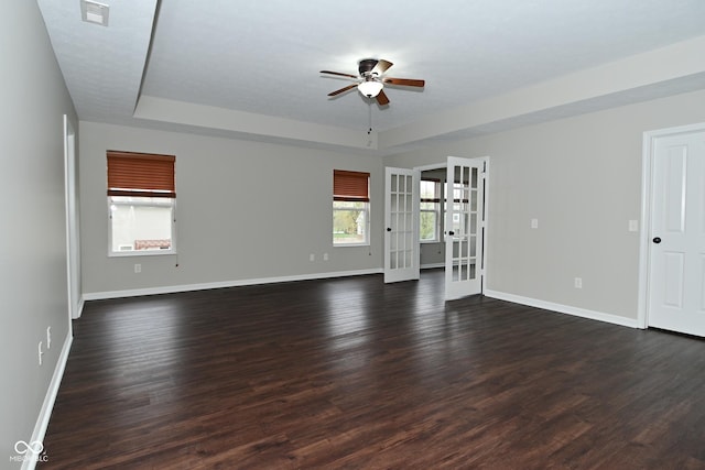 unfurnished living room with ceiling fan, baseboards, french doors, and a tray ceiling