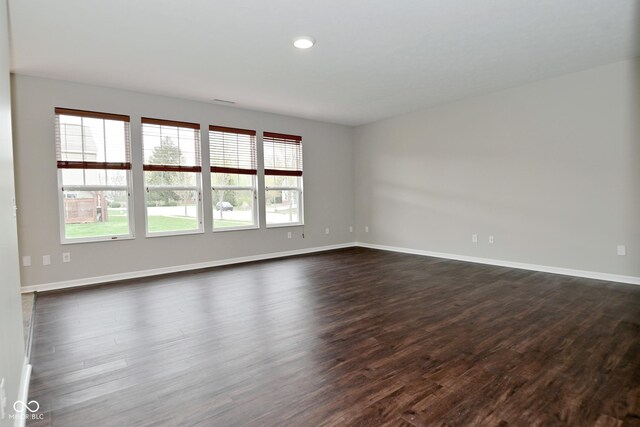 unfurnished room with dark wood-type flooring, baseboards, and recessed lighting