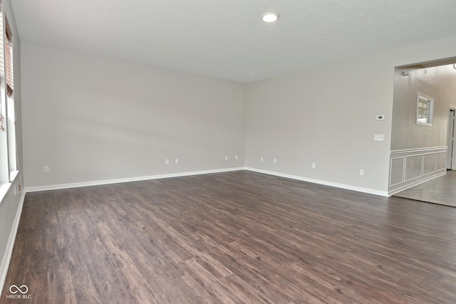 spare room with dark wood finished floors, baseboards, and recessed lighting