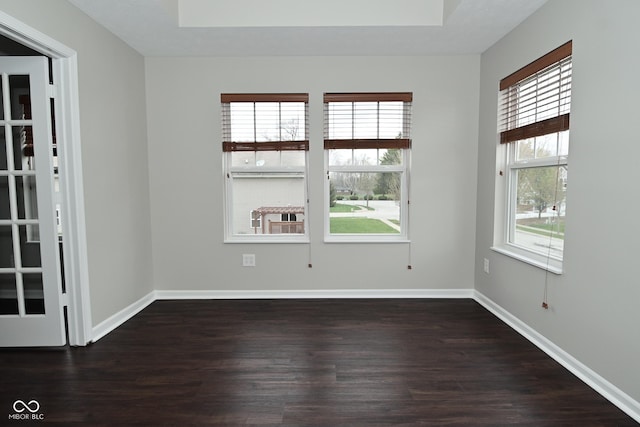 unfurnished room with baseboards and dark wood-style flooring