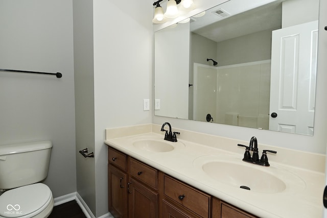 bathroom featuring a shower, toilet, a sink, and visible vents