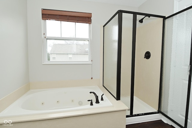 bathroom with a shower stall and a tub with jets