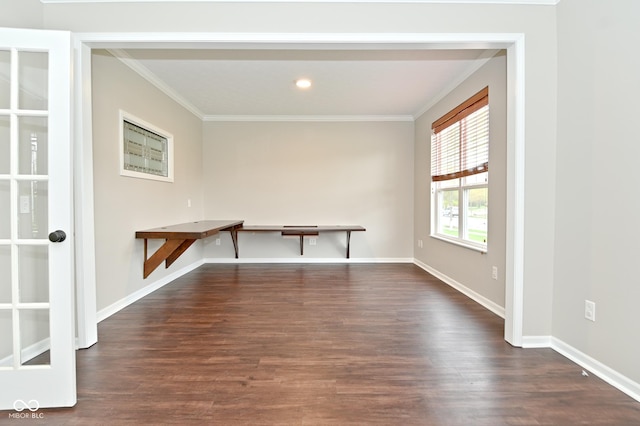 unfurnished dining area featuring baseboards, crown molding, and wood finished floors