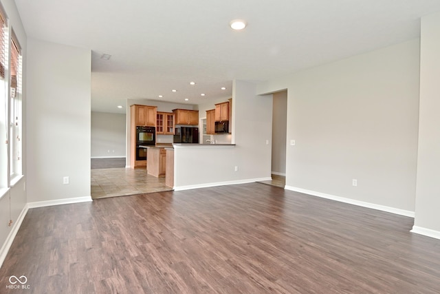 unfurnished living room featuring baseboards, dark wood-style floors, and recessed lighting
