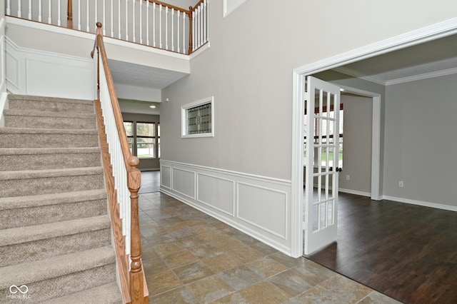 stairway featuring stone finish flooring, baseboards, and crown molding