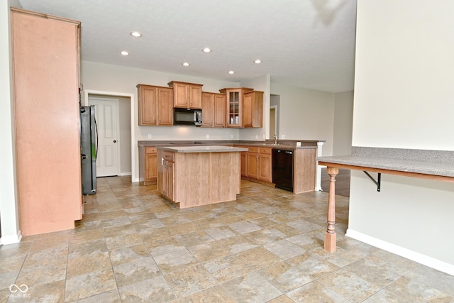 kitchen featuring baseboards, recessed lighting, black appliances, and a kitchen island