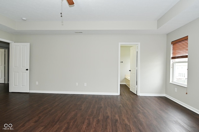 unfurnished room with baseboards, a ceiling fan, and dark wood-style floors