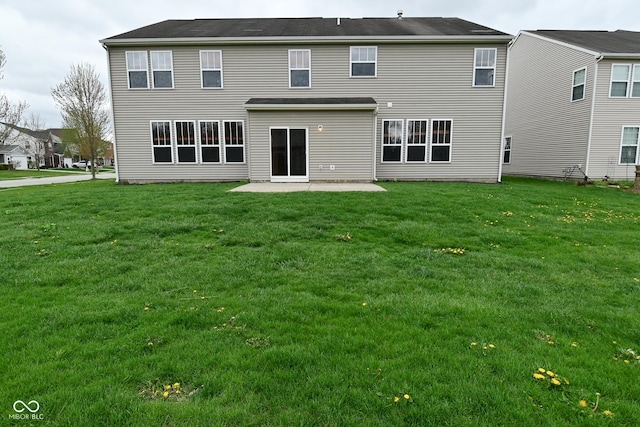 rear view of property with a yard and a patio area