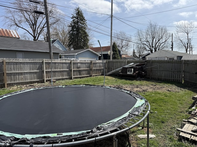 view of yard with a trampoline and a fenced backyard