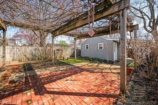 view of patio featuring an outbuilding, a pergola, and fence